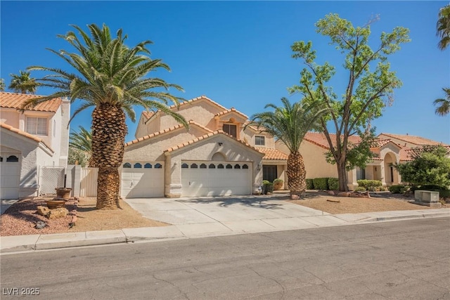 mediterranean / spanish-style home with a garage, stucco siding, driveway, and a tiled roof