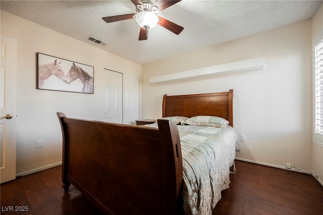 bedroom featuring wood finished floors, a textured ceiling, a closet, multiple windows, and baseboards