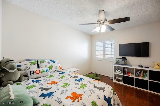 bedroom featuring a textured ceiling, wood finished floors, a ceiling fan, and baseboards