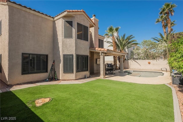 back of property with stucco siding and a patio area