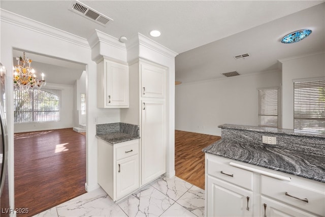 5148 Forest Oaks Dr, Las Vegas, NV 89149 - kitchen featuring crown molding, open floor plan, white cabinets, dark stone counters, and a chandelier