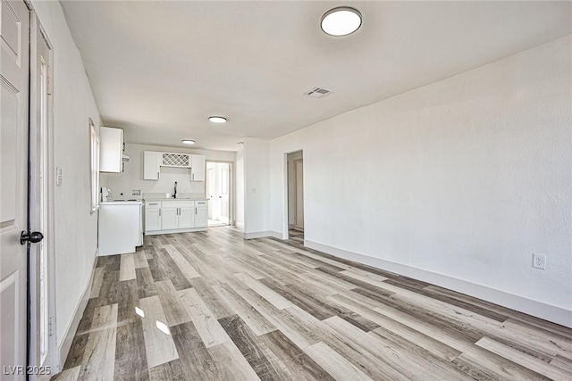 603 W Adams Ave, Las Vegas, NV 89106 - unfurnished living room with light wood-style flooring, baseboards, and a sink