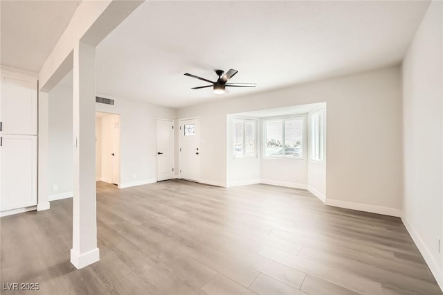 unfurnished living room with a ceiling fan, wood finished floors, and baseboards