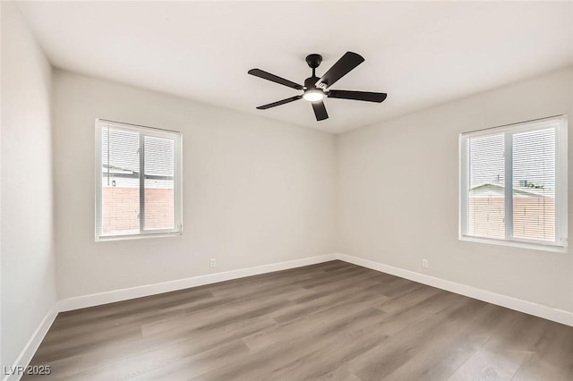 unfurnished room featuring dark wood-style flooring, baseboards, and a ceiling fan
