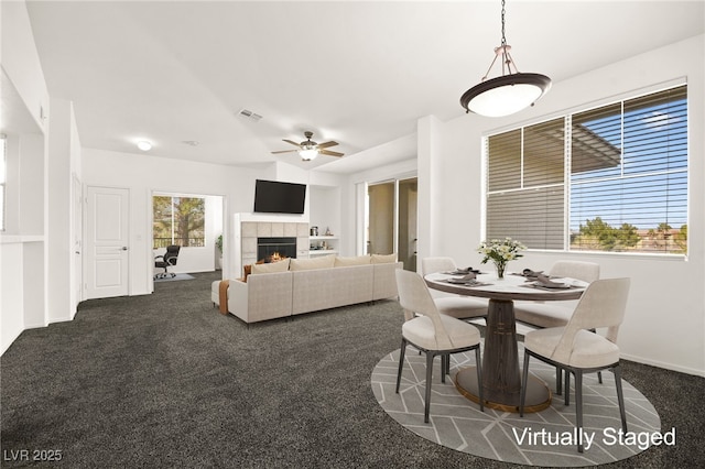 913 Duckhorn Ct Unit 204, Las Vegas, NV 89144 - dining room with dark colored carpet, ceiling fan, a tiled fireplace, and baseboards
