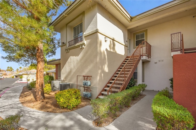 913 Duckhorn Ct Unit 204, Las Vegas, NV 89144 - view of side of home featuring stucco siding, stairway, and central AC unit