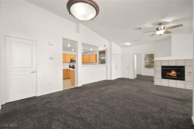 913 Duckhorn Ct Unit 204, Las Vegas, NV 89144 - unfurnished living room featuring carpet flooring, lofted ceiling, a tiled fireplace, and a ceiling fan