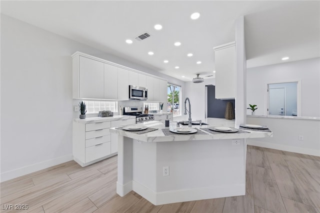 2029 Poppywood Ave, Henderson, NV 89012 - kitchen featuring appliances with stainless steel finishes, white cabinetry, a sink, recessed lighting, and light wood-type flooring