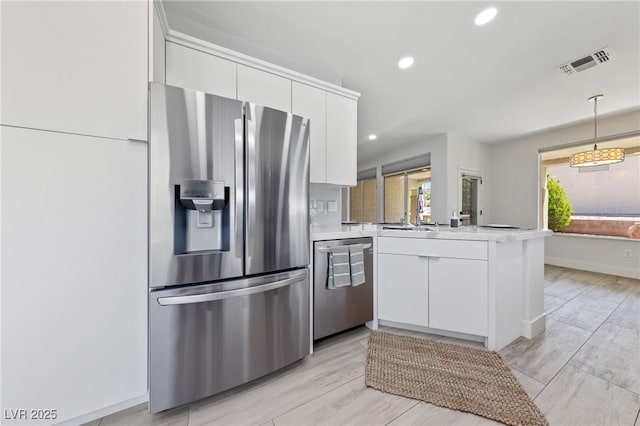 2029 Poppywood Ave, Henderson, NV 89012 - kitchen featuring stainless steel appliances, a peninsula, white cabinets, light countertops, and pendant lighting