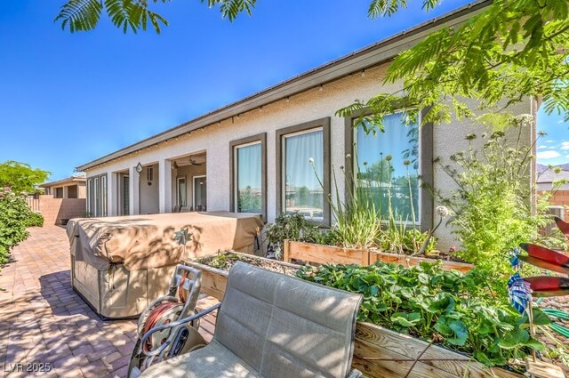 4893 E Cedar Creek Way, Pahrump, NV 89061 - view of side of home featuring stucco siding, a patio, and fence
