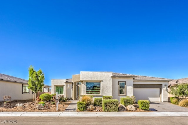 4893 E Cedar Creek Way, Pahrump, NV 89061 - view of front of house with driveway, an attached garage, stucco siding, and a tiled roof