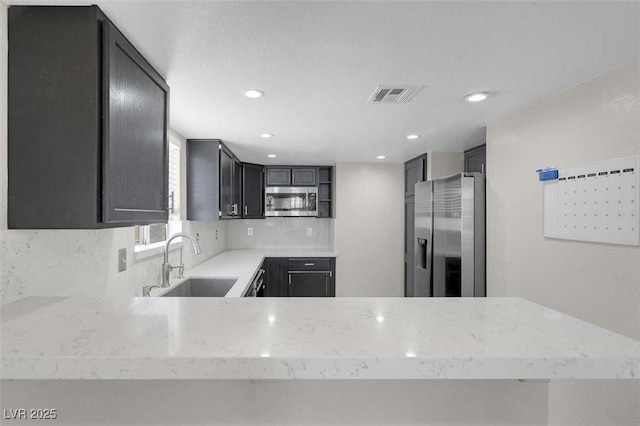1622 Lorna Dr, Henderson, NV 89011 - kitchen with appliances with stainless steel finishes, a sink, light stone counters, backsplash, and recessed lighting