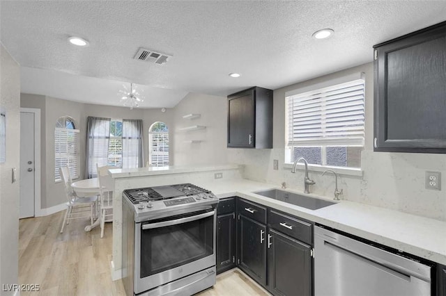 1622 Lorna Dr, Henderson, NV 89011 - kitchen featuring stainless steel appliances, a sink, a textured ceiling, a peninsula, and light countertops