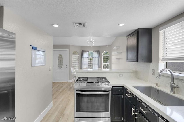 1622 Lorna Dr, Henderson, NV 89011 - kitchen with appliances with stainless steel finishes, a sink, a textured ceiling, a peninsula, and light countertops