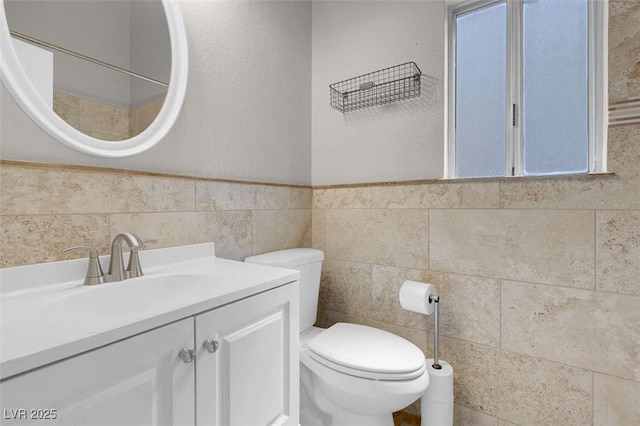 1622 Lorna Dr, Henderson, NV 89011 - bathroom featuring toilet, vanity, tile walls, and a wainscoted wall