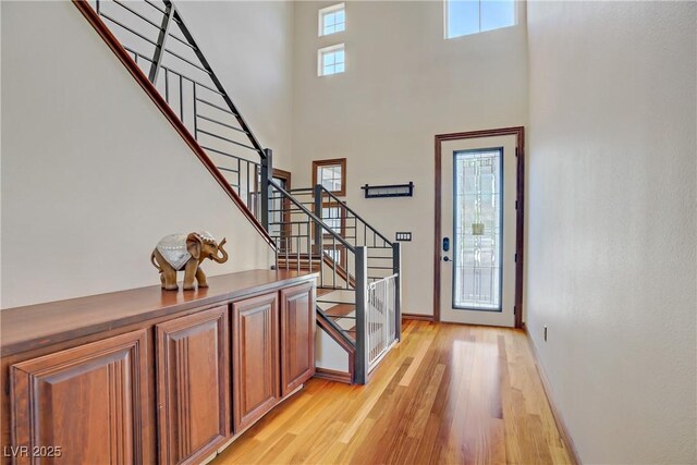 10520 Maystar Ln, Las Vegas, NV 89135 - entryway featuring light wood finished floors, a high ceiling, stairway, and baseboards
