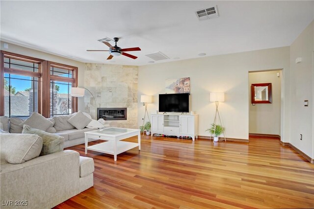 10520 Maystar Ln, Las Vegas, NV 89135 - living area featuring ceiling fan, light wood finished floors, baseboards, and a tiled fireplace
