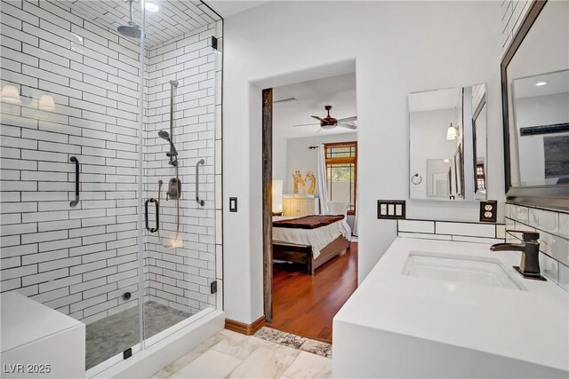 10520 Maystar Ln, Las Vegas, NV 89135 - ensuite bathroom with a sink, a shower stall, ceiling fan, marble look tile flooring, and baseboards