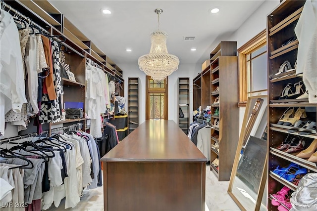 spacious closet featuring a chandelier
