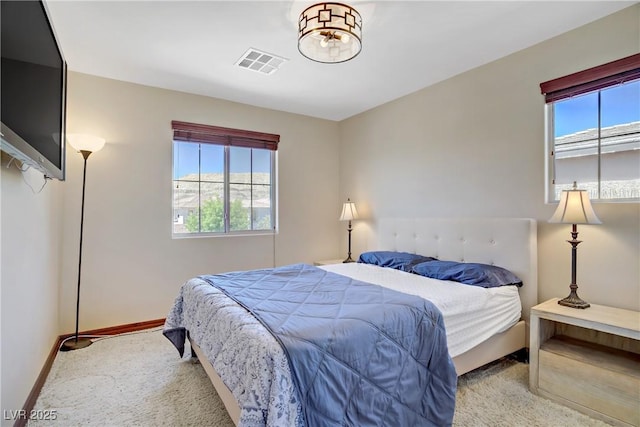 carpeted bedroom with multiple windows and baseboards