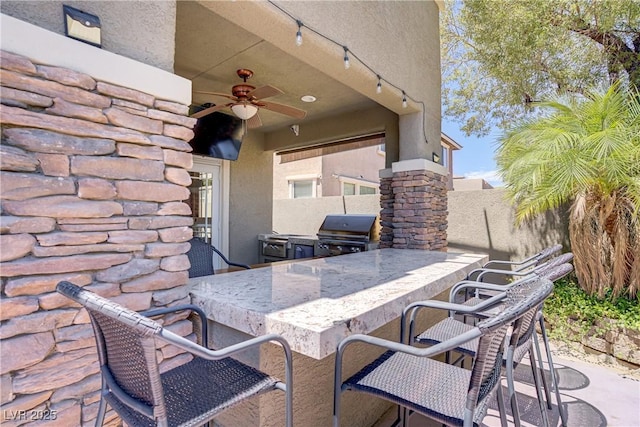 view of patio with a grill, area for grilling, a ceiling fan, and fence