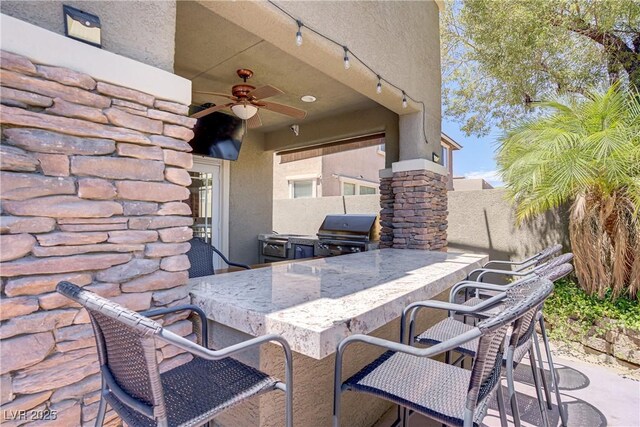 10520 Maystar Ln, Las Vegas, NV 89135 - view of patio / terrace featuring grilling area, an outdoor kitchen, a ceiling fan, and fence