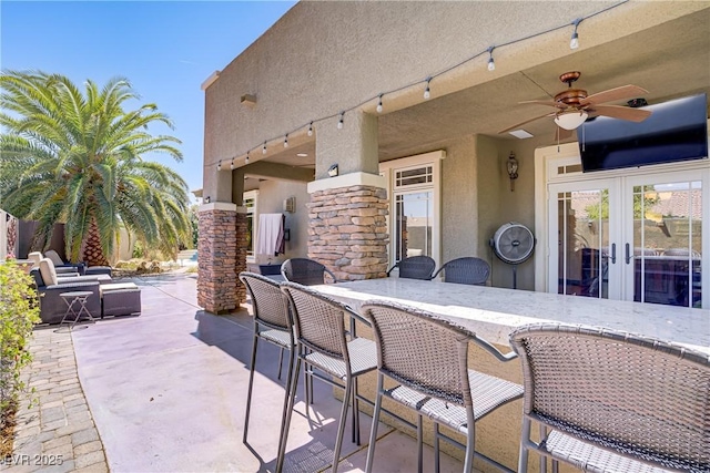 view of patio / terrace featuring a ceiling fan and french doors