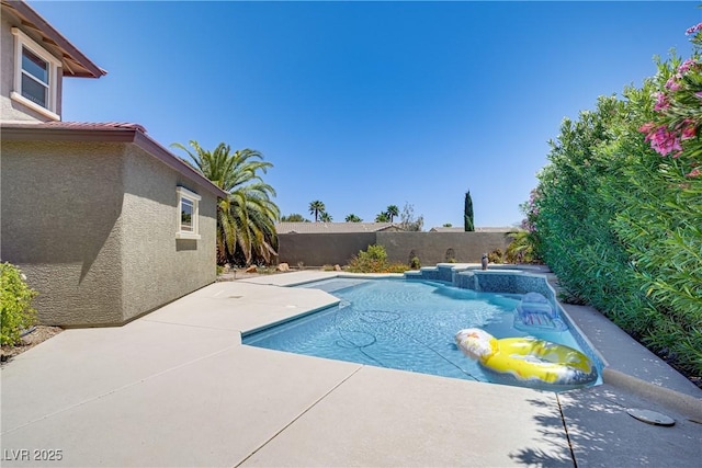 view of swimming pool featuring a fenced backyard, a patio area, and a pool with connected hot tub