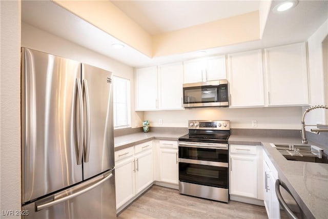 6160 Rumrill St Unit 121, Las Vegas, NV 89113 - kitchen featuring appliances with stainless steel finishes, a sink, white cabinetry, recessed lighting, and light wood finished floors