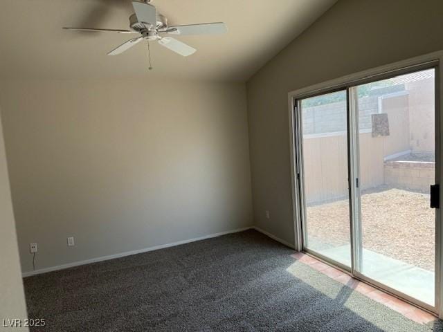 spare room featuring lofted ceiling, dark colored carpet, ceiling fan, and baseboards