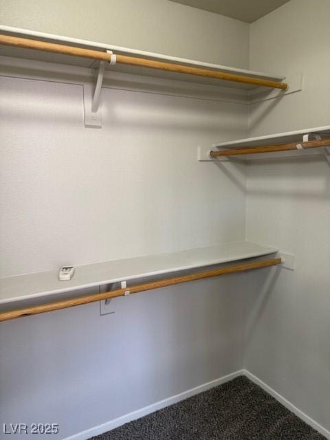 spacious closet featuring dark carpet