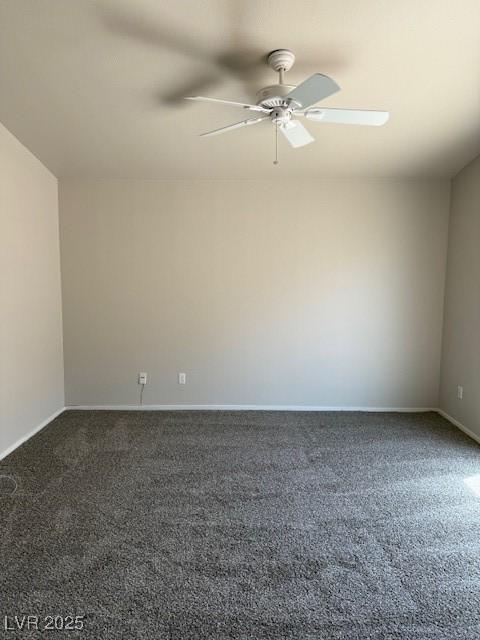empty room featuring dark carpet, a ceiling fan, and baseboards