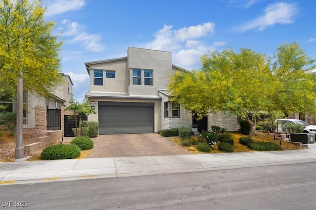 9710 Hiking Ave, Las Vegas, NV 89166 - contemporary home featuring an attached garage, stone siding, driveway, and stucco siding