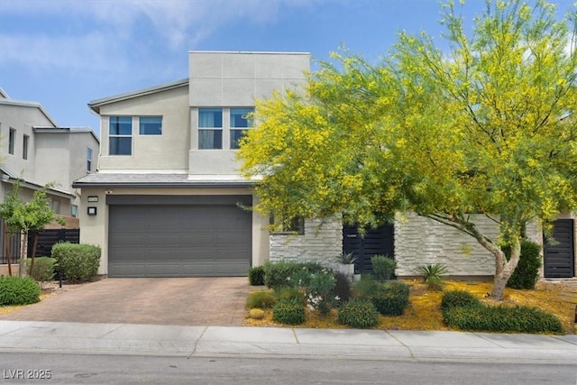 9710 Hiking Ave, Las Vegas, NV 89166 - view of front of house with a garage, decorative driveway, stucco siding, and stone siding