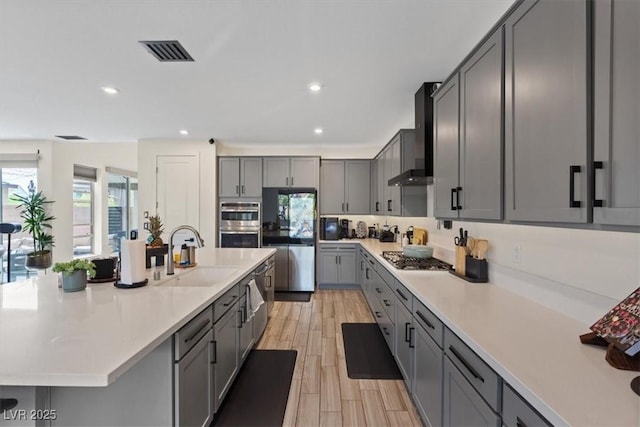9710 Hiking Ave, Las Vegas, NV 89166 - kitchen with a sink, wall chimney exhaust hood, stainless steel appliances, gray cabinetry, and light countertops