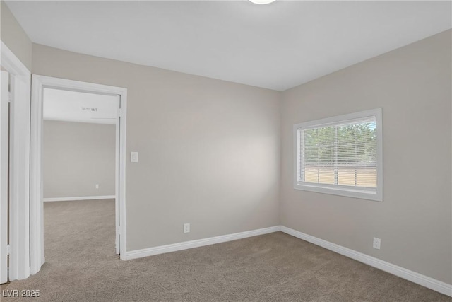 carpeted spare room featuring baseboards