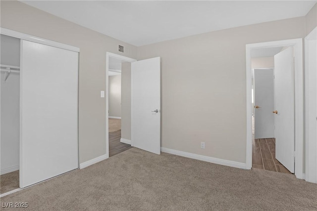 unfurnished bedroom featuring carpet, a closet, and baseboards
