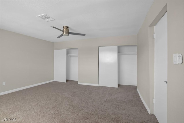 unfurnished bedroom featuring multiple closets, carpet floors, ceiling fan, and baseboards