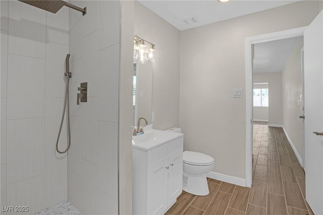 full bath featuring toilet, tiled shower, vanity, and wood tiled floors