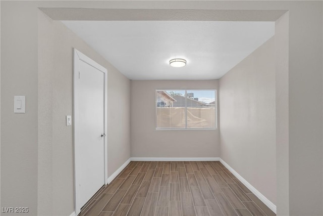 unfurnished room with baseboards and wood finished floors