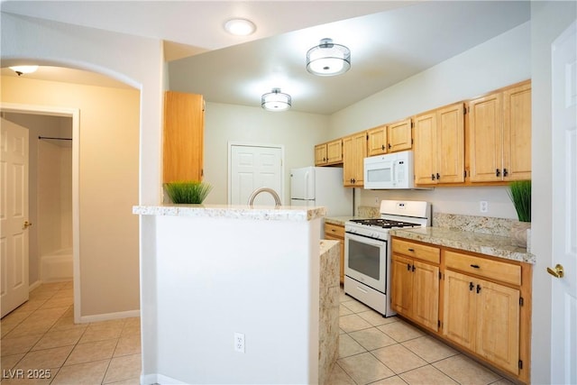 8555 W Russell Rd Unit 2020, Las Vegas, NV 89113 - kitchen with white appliances, light tile patterned flooring, light brown cabinetry, and a peninsula