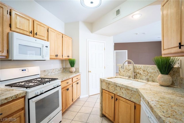 8555 W Russell Rd Unit 2020, Las Vegas, NV 89113 - kitchen with white appliances, a sink, light tile patterned floors, light brown cabinets, and light stone countertops