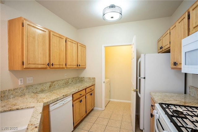8555 W Russell Rd Unit 2020, Las Vegas, NV 89113 - kitchen with white appliances, a sink, light tile patterned floors, light brown cabinets, and washer / clothes dryer