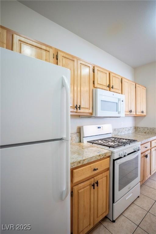 8555 W Russell Rd Unit 2020, Las Vegas, NV 89113 - kitchen featuring white appliances, light brown cabinetry, and light tile patterned flooring
