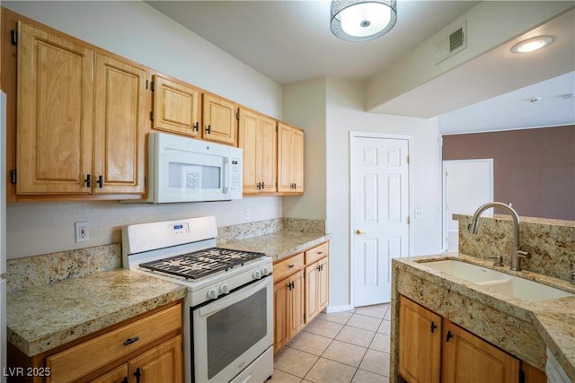 8555 W Russell Rd Unit 2020, Las Vegas, NV 89113 - kitchen with white appliances, a sink, light tile patterned flooring, and light stone counters
