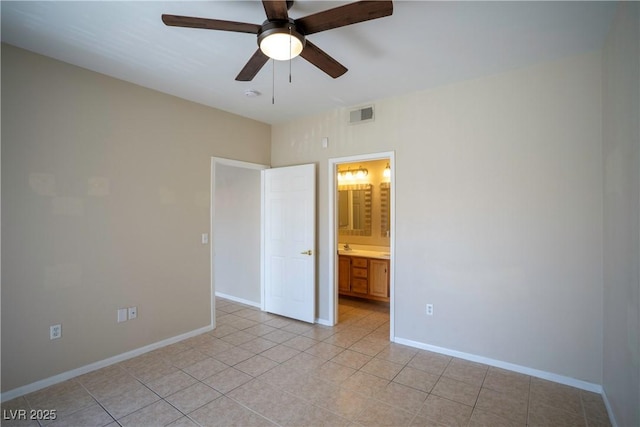 8555 W Russell Rd Unit 2020, Las Vegas, NV 89113 - unfurnished bedroom with light tile patterned flooring, baseboards, ensuite bath, and ceiling fan