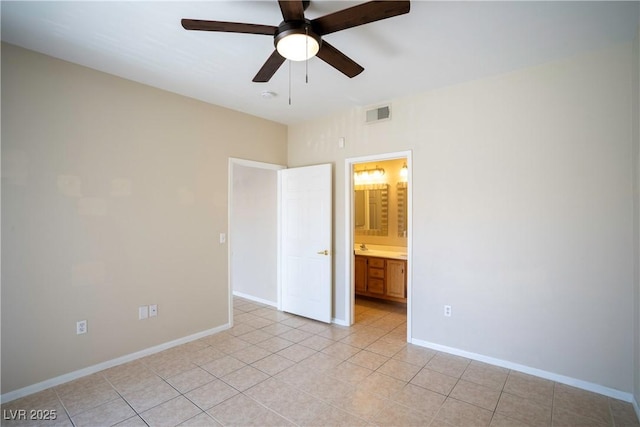 8555 W Russell Rd Unit 2020, Las Vegas, NV 89113 - unfurnished bedroom with light tile patterned floors, baseboards, ensuite bath, and a ceiling fan