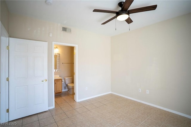 8555 W Russell Rd Unit 2020, Las Vegas, NV 89113 - unfurnished bedroom with baseboards, light tile patterned floors, connected bathroom, and a ceiling fan