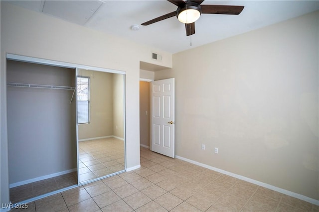 8555 W Russell Rd Unit 2020, Las Vegas, NV 89113 - unfurnished bedroom featuring a closet, light tile patterned floors, a ceiling fan, and baseboards