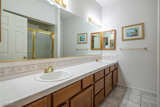 10140 W Tropical Pkwy, Las Vegas, NV 89149 - full bathroom featuring a shower stall, double vanity, baseboards, and tile patterned flooring